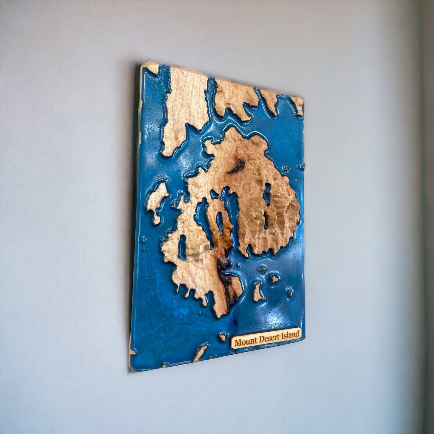 Wooden relief map of Mount Desert Island on a blue background