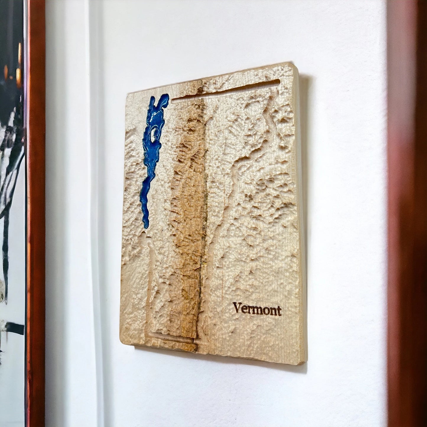 A 3D topographic map of the state of Vermont with blue epoxy detailing Lake Champlain.