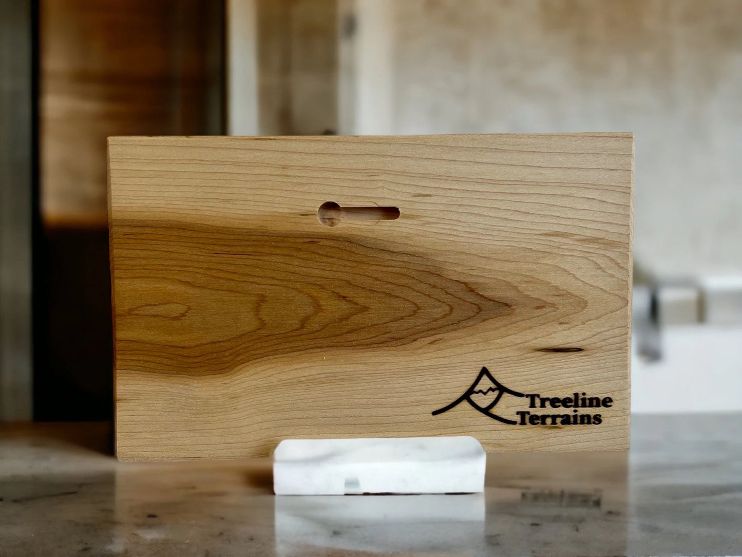 Wooden 3d relief map backside with keyhole detail and 'Treeline Terrains' logo on a marble surface