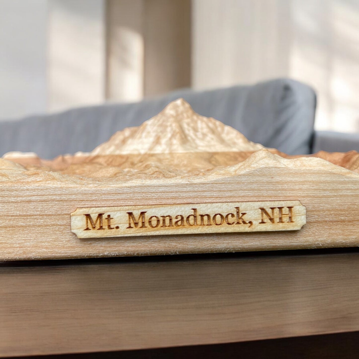 A wooden 3D relief map of Mt. Monadnock, NH, with the name engraved on the front.