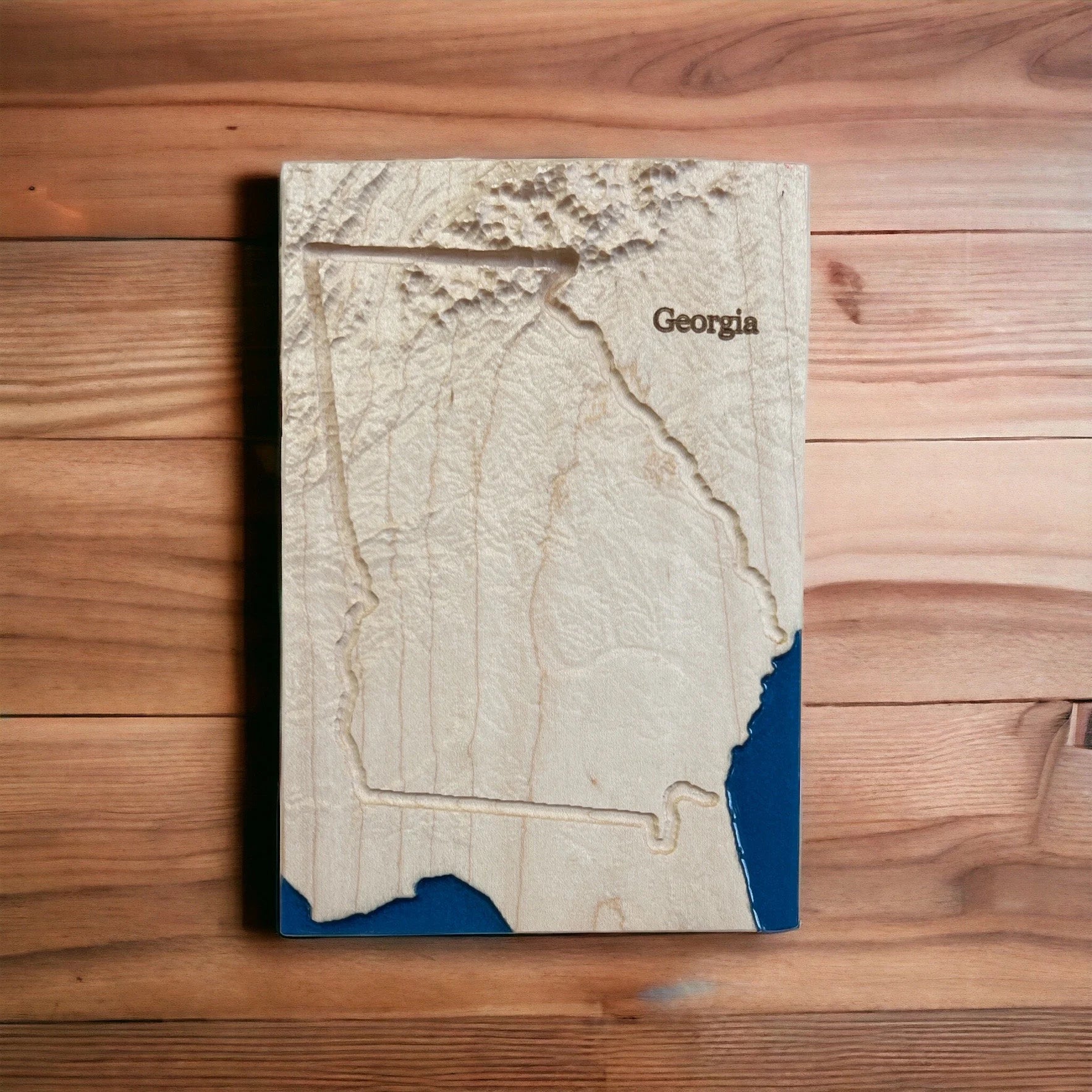 Wooden topo map of Georgia on a wooden surface