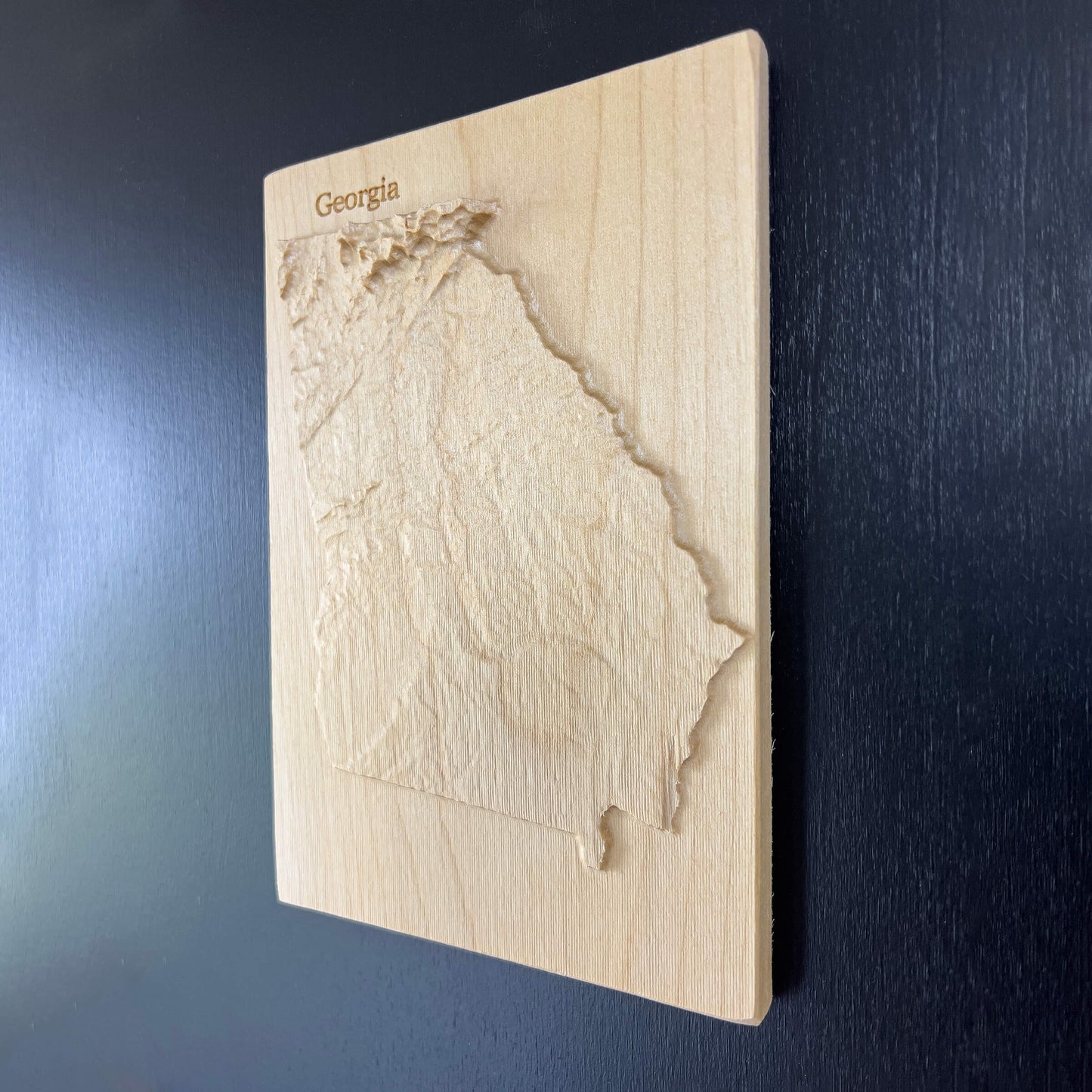 Wooden relief map of Georgia on a dark blue background