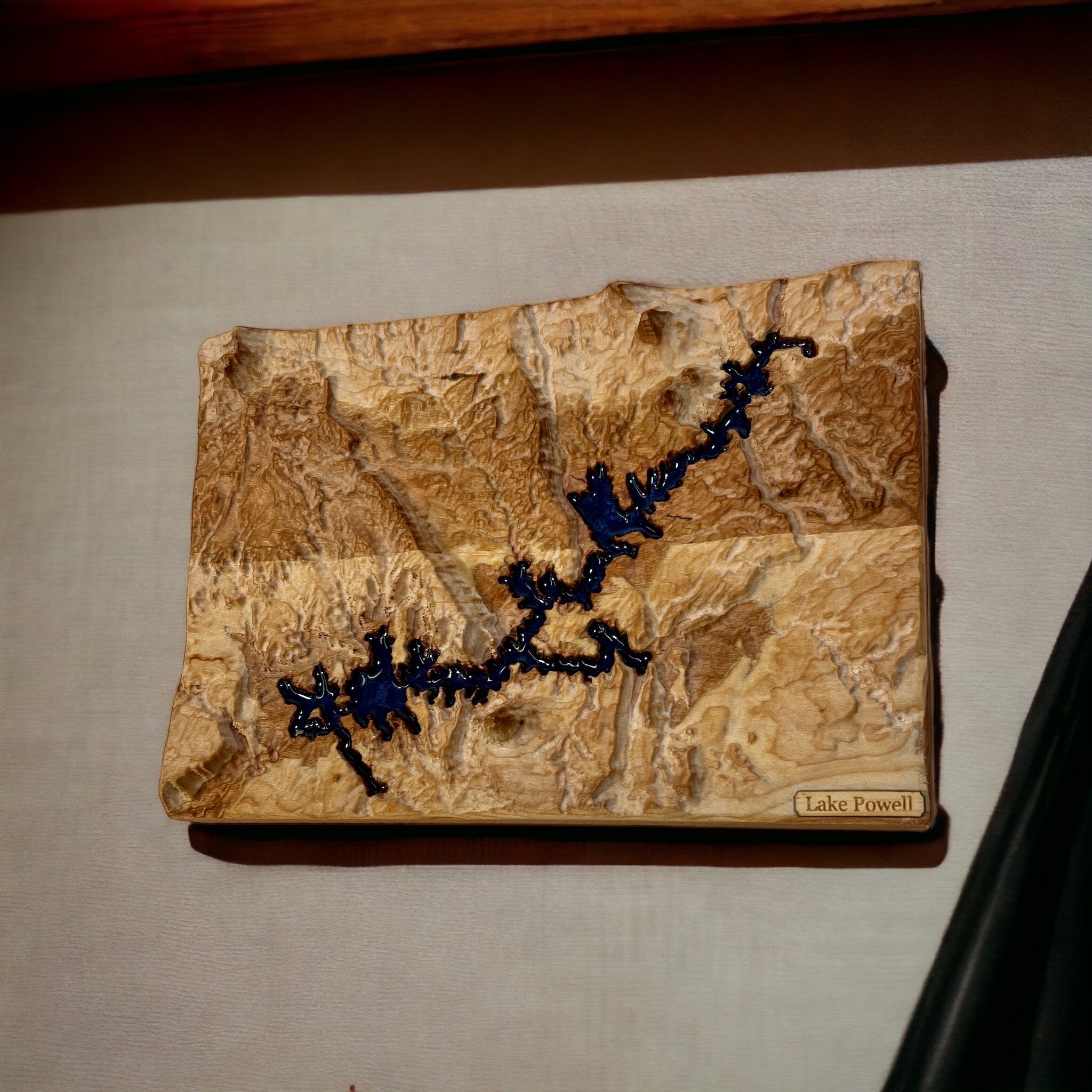 Lake powell in a 3d wooden topographic map with blue epoxy for water on a textured wall