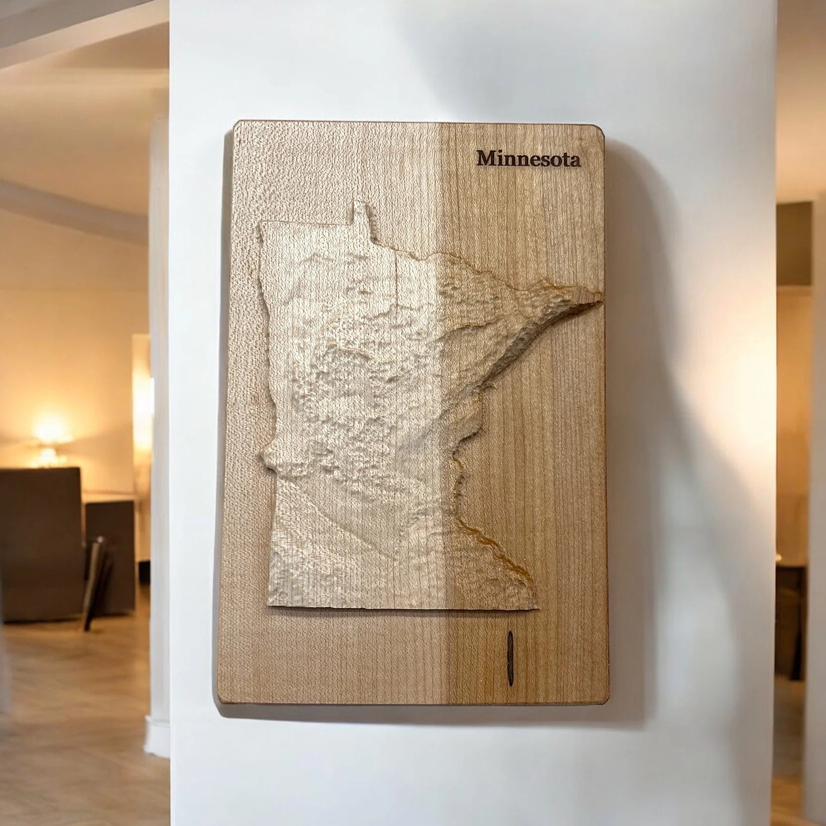 Wooden map wall art of Minnesota with 'Minnesota' text on a white wall.
