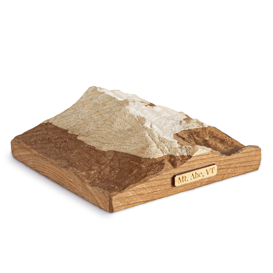 A 3D topographic map of Mount Abraham in Vermont, USA. carved in wood with 2-tone wood layers depicting a snowline.