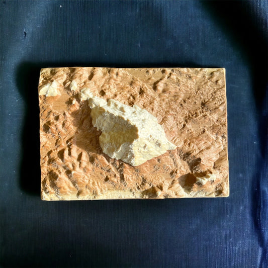 top view of Mt Monadnock wood carving on dark blue background
