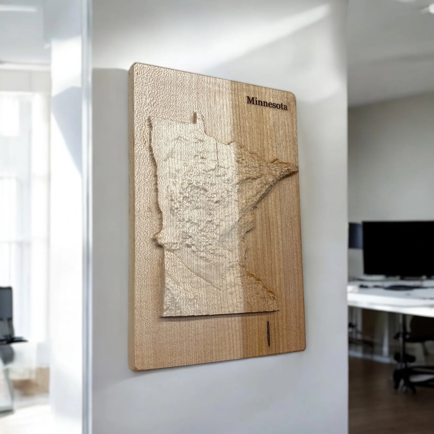 Wooden map of Minnesota on a wall in an office setting
