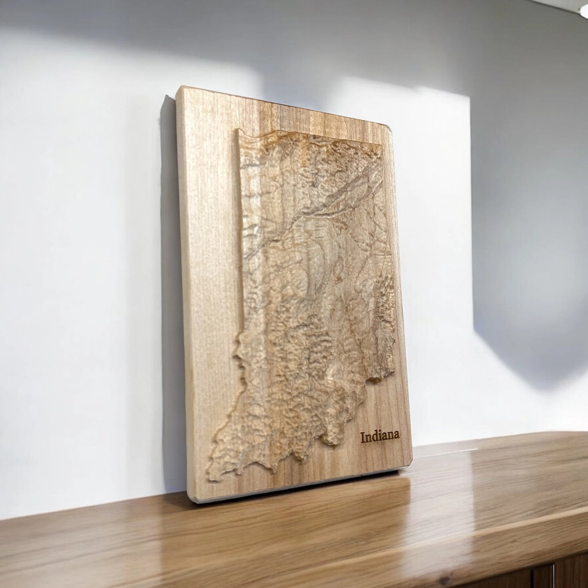 Wooden relief map of Indiana on a white wall