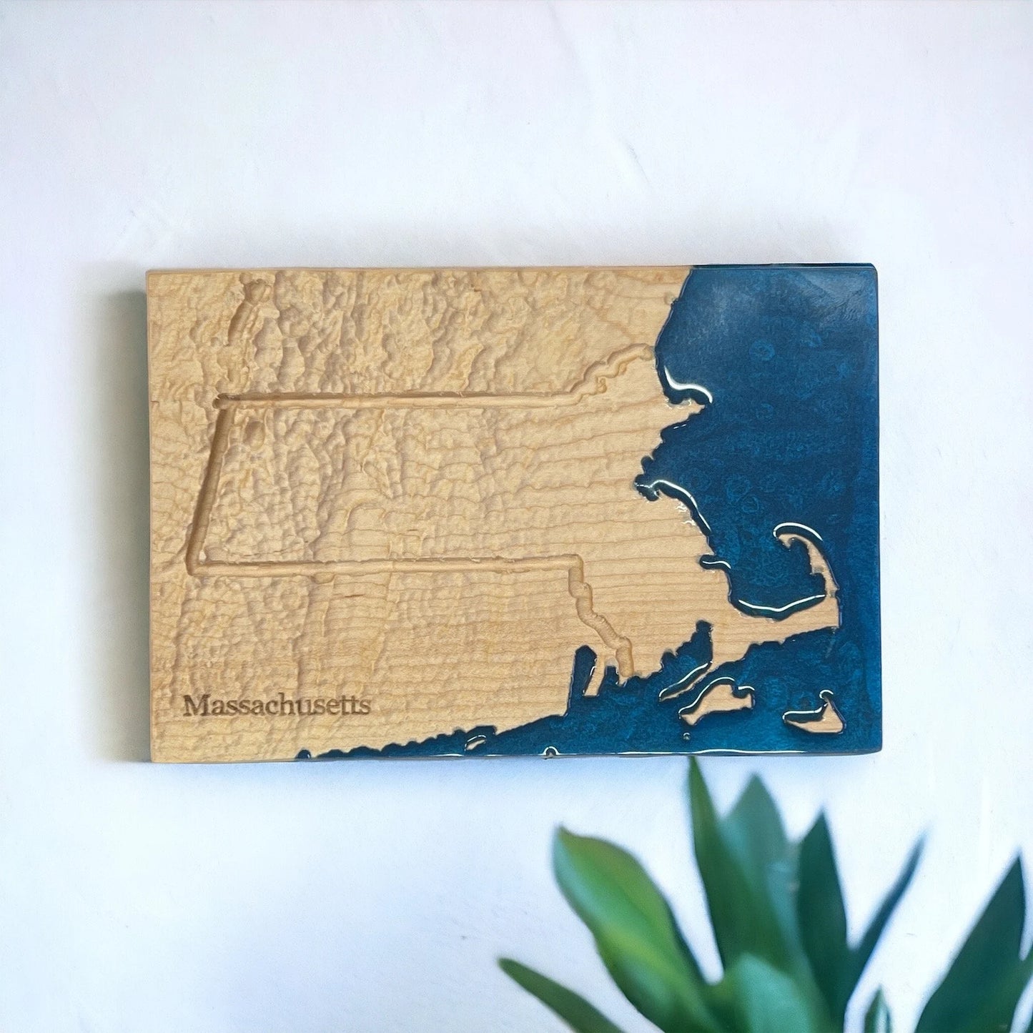 Wooden plaque with a map of Massachusetts on a white background