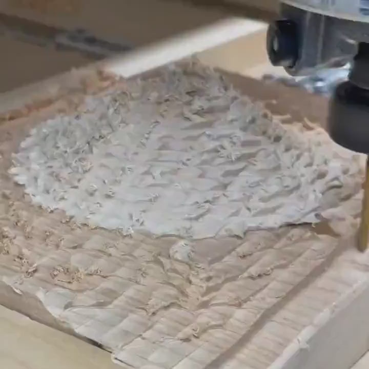 video shot in time lapse of a router head cutting a 3D topographic terrain out of wood