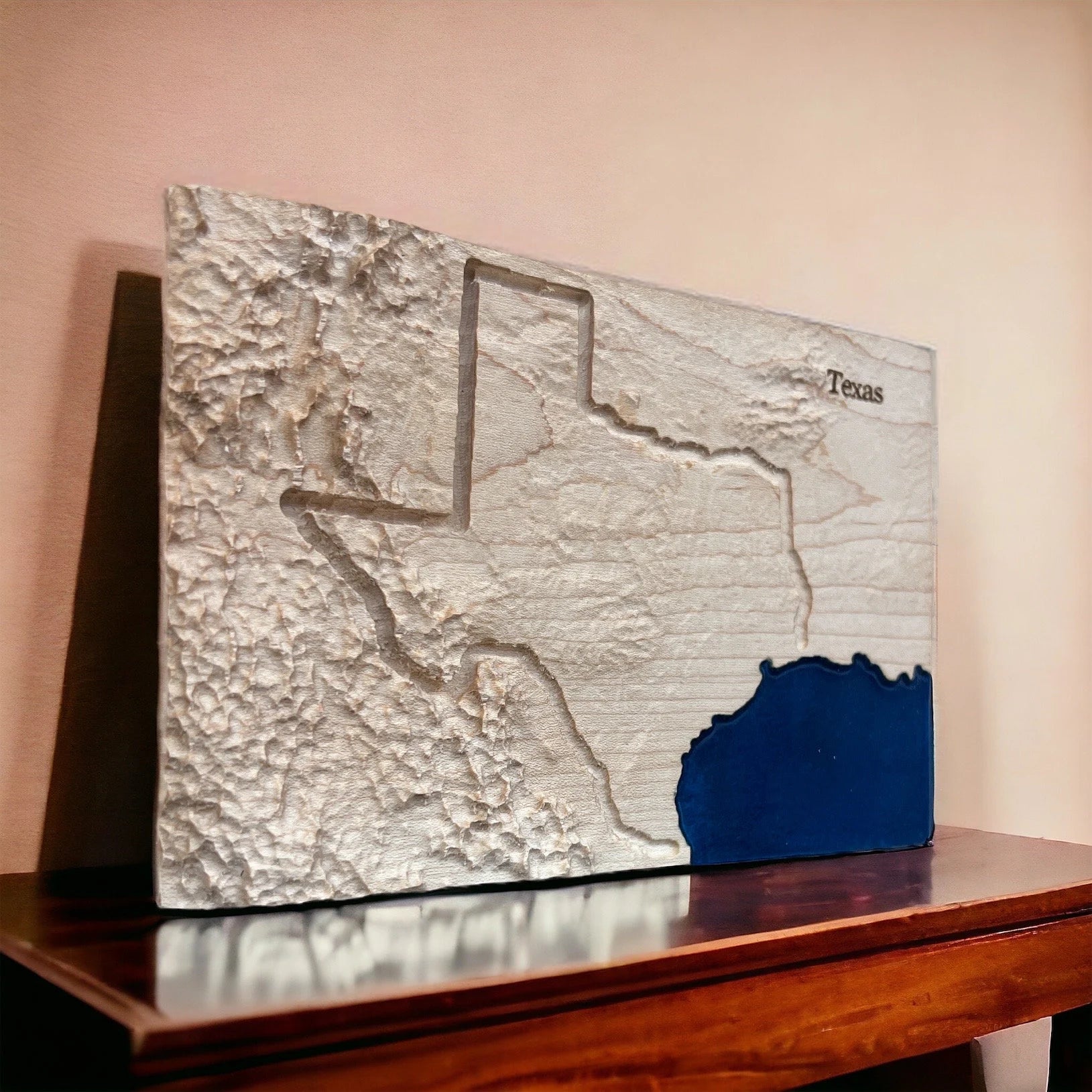 Topographic map of Texas on a wooden stand with a plain background