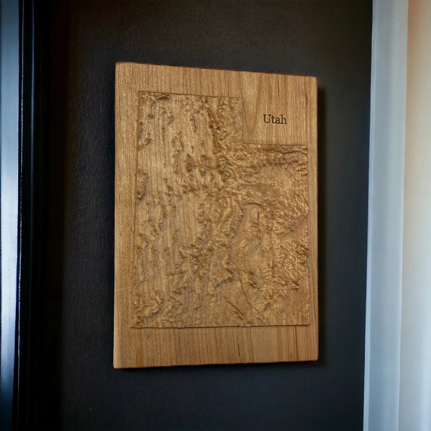 Wooden relief map of Utah on a dark wall