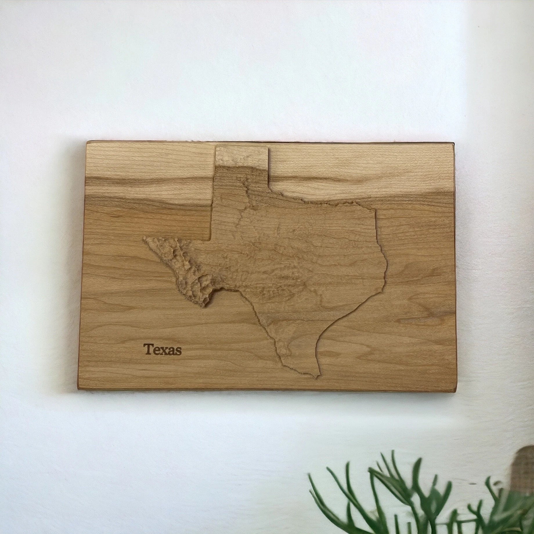 Wooden wall art with a 3D cutout of Texas on a white background