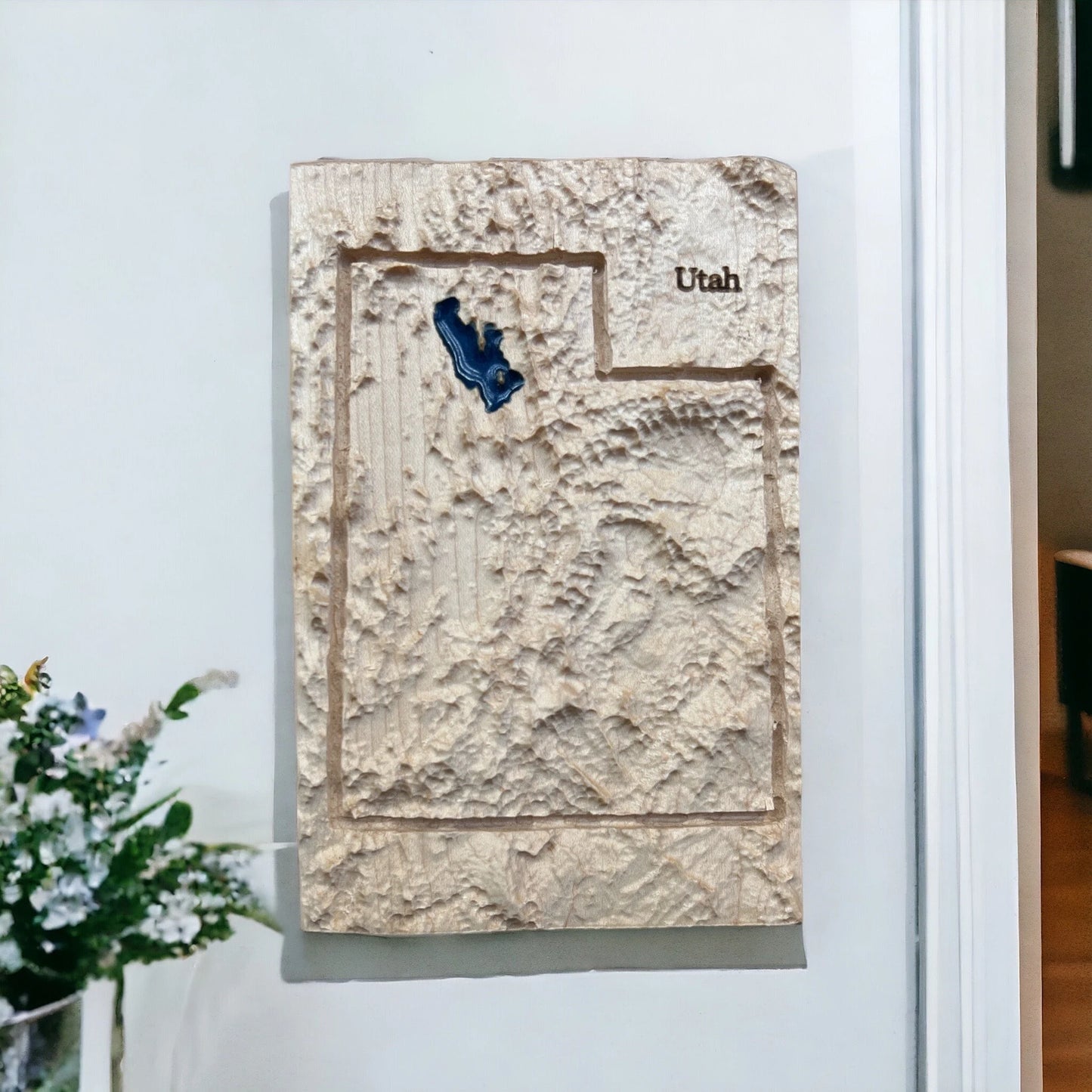3D map of Utah on a white wall with a decorative plant.