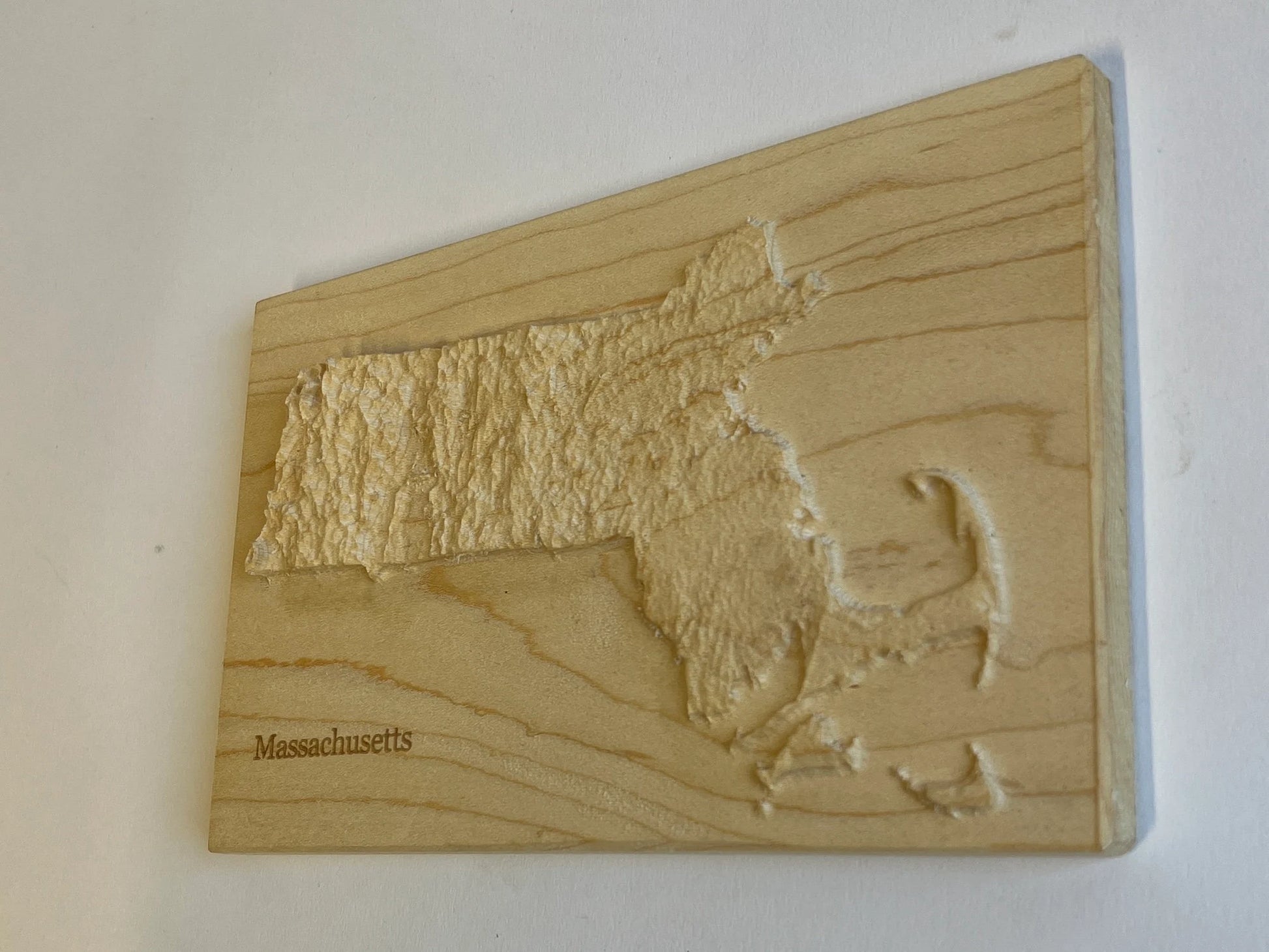 Wooden relief map of Massachusetts on a white background