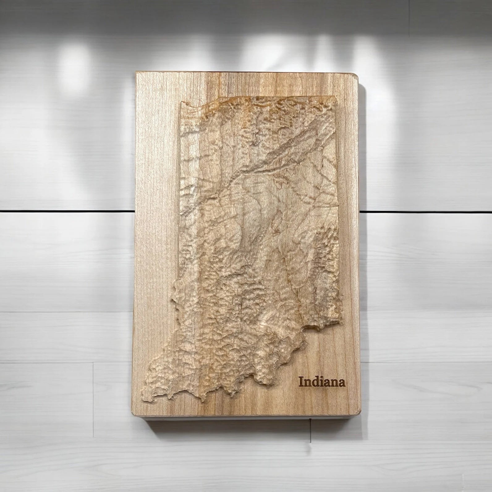 Wooden topo map of Indiana on a light gray background