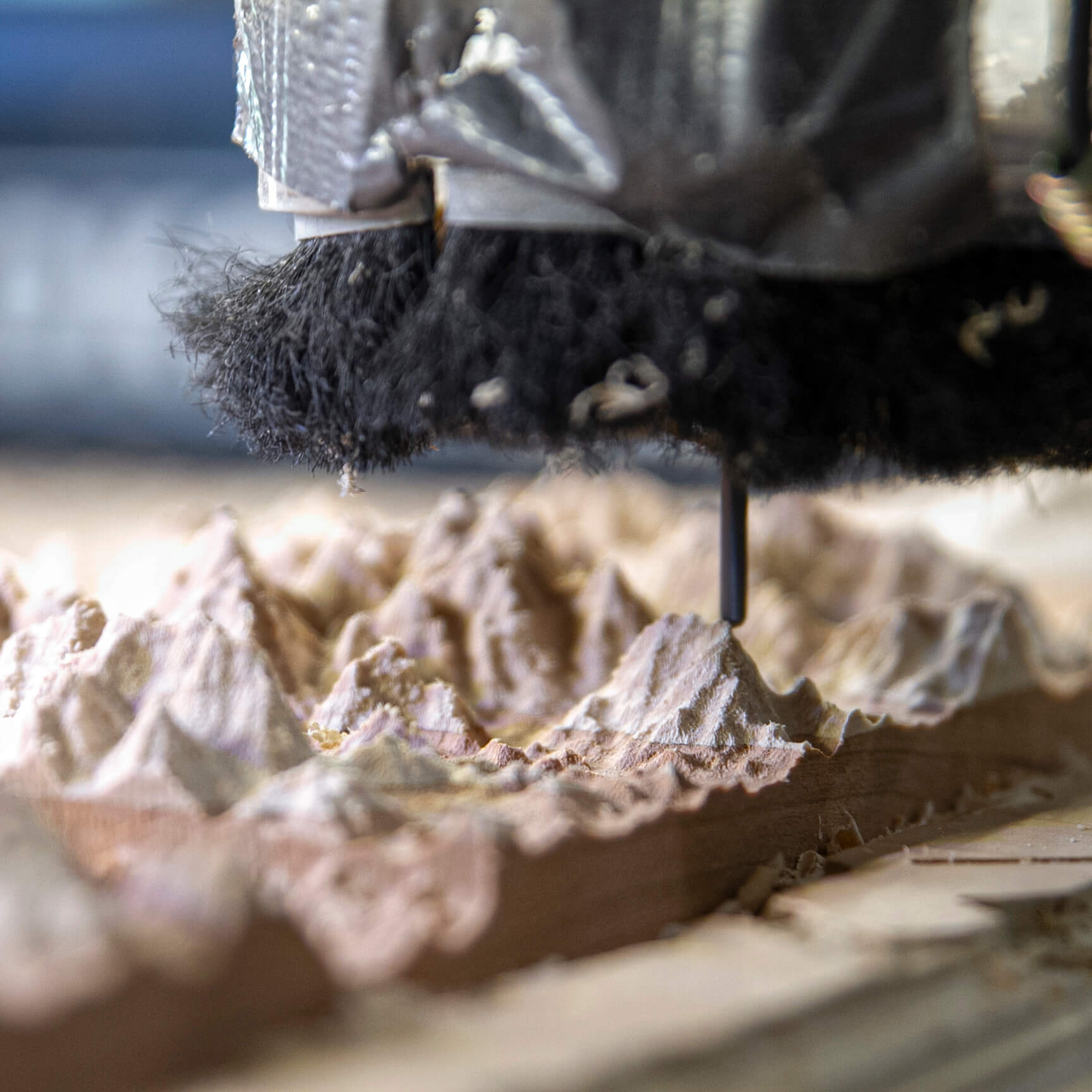 Close-up of a 3D wooden topo map of lake champlain being shaped by the router head