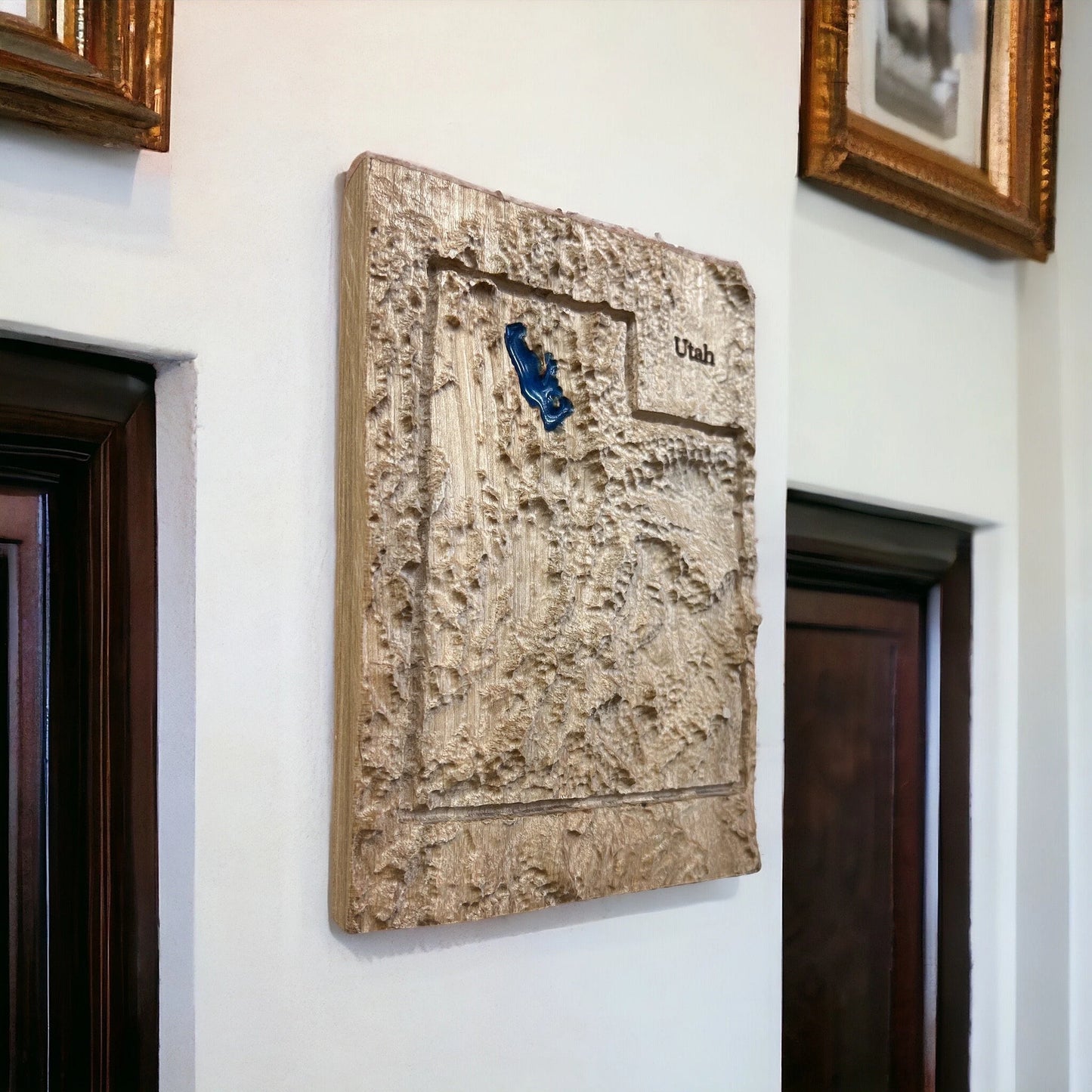 Wooden plaque with a topographic 3d map and 'Utah' text, mounted on a wall.
