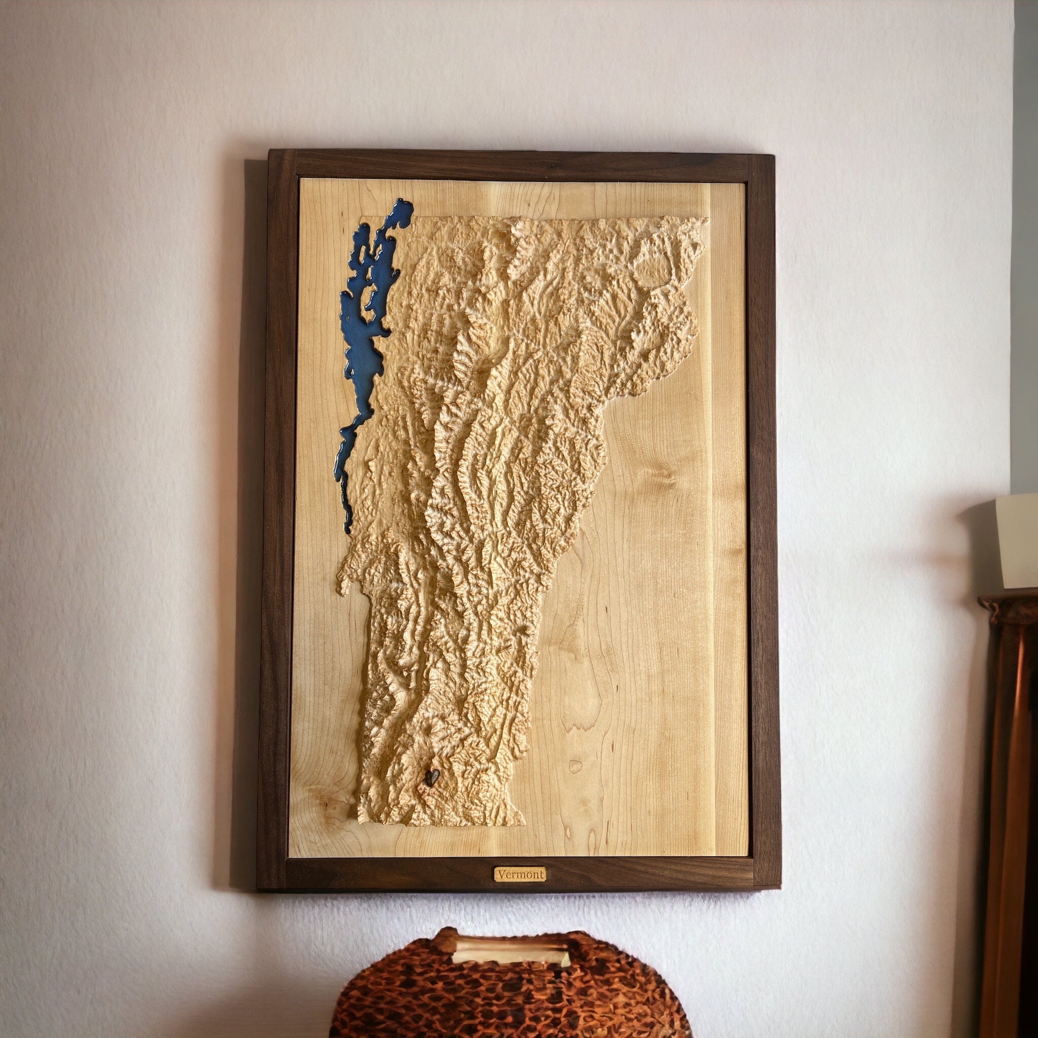 topographic map of vermont with alke champlain in blue epoxy carved in wood and hanging on a white wall